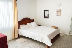 a bed with white sheets and pillows in a bedroom at Casa Lucy Alojamientos in Palmira