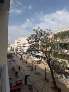 a street in a city with a tree and buildings at PontesMar Apartamentos Central in Quarteira