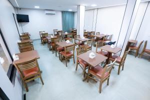 a dining room with wooden tables and chairs at Barak Hotel in Nova Mutum