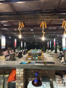 a dining room with a long table and chairs at Loopmoto Riverside Homestay in Làng Lap