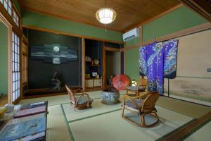 a living room with chairs and a table at ようこそ月の宿へ in Shindembaru