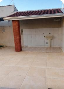 an outside view of a house with a toilet on a tile floor at Recanto Sossego Wi-Fi 3 quartos 3 banheiros 2 chuveiros Espaço amplo churrasqueira in Espirito Santo Do Pinhal