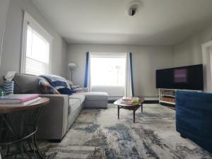 a living room with a couch and a tv at The Fairview - North of Boston Furnished Home in Peabody