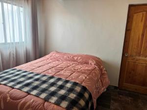 a bedroom with a bed with a blanket on it at conixia in San Pedro de Atacama