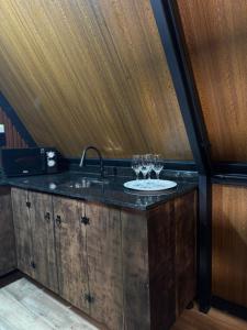 a kitchen with a sink with wine glasses on it at Chalé Amor & Serra in Lauro Müller