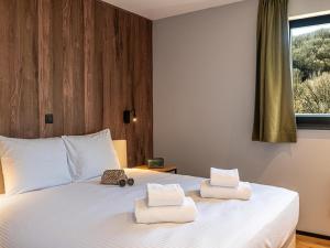 a bedroom with a white bed with towels on it at Villa in Belgium with Private Terrace in La-Roche-en-Ardenne