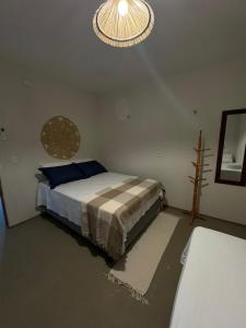 a bedroom with a bed and a chandelier at Pousada Raízzes in Amontada