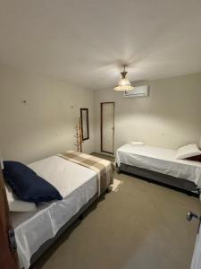 a bedroom with two beds and a chandelier at Pousada Raízzes in Amontada