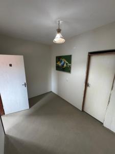 an empty room with a white door and a room with a door at Pousada Raízzes in Amontada