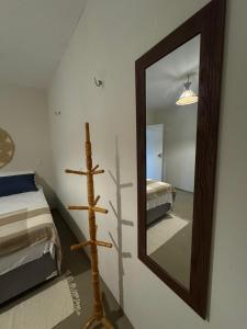 a mirror on a wall next to a bedroom at Pousada Raízzes in Amontada