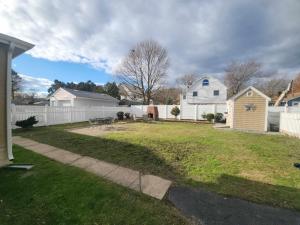 a yard with a white fence and a house at The Fairview - North of Boston Furnished Home in Peabody