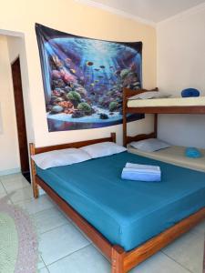 a room with two bunk beds and a painting on the wall at Pousada Mar e Sol in Peruíbe