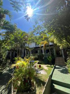 a house with trees and plants in front of it at Pousada Encanto da Ilha in Praia de Araçatiba