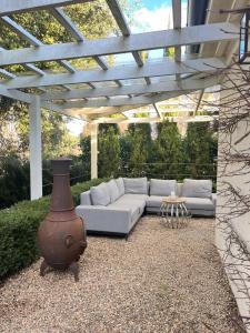a living room with a white couch under a pergola at Oakwood Guesthouse in Berrima