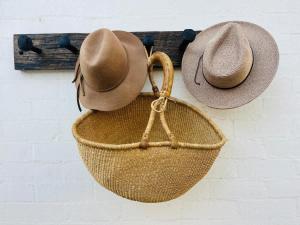 two straw hats are hanging on a wall at Oakwood Guesthouse in Berrima