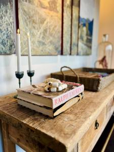 a stack of books sitting on a table with two candles at Oakwood Guesthouse in Berrima +15 photos