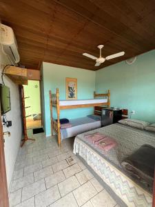 a bedroom with two beds and a ceiling at Pousada Encanto da Ilha in Praia de Araçatiba