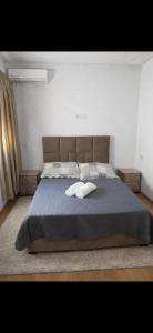 a bedroom with a large bed with a blue blanket at résidence avec piscine wifi et parking gratuit in Bouskoura