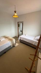 a bedroom with two beds and a chandelier at Pousada Raízzes in Amontada