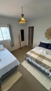a bedroom with two beds and a chandelier at Pousada Raízzes in Amontada