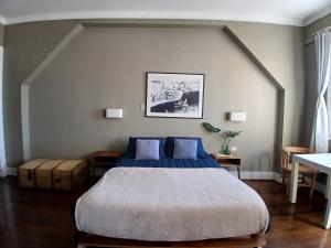 a bedroom with a large bed with blue pillows at El Navegante B&B in Valparaíso