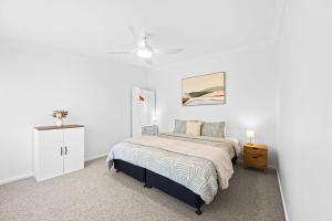 a white bedroom with a bed and a dresser at Timber Mill Cottage - Mansfield in Mansfield
