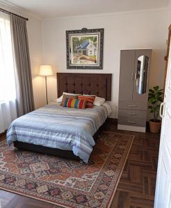 a bedroom with a large bed and a rug at Hospedaje Paris in Cusco