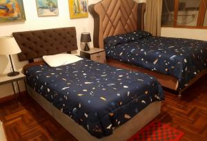 a bedroom with two beds with blue comforter at Hospedaje Paris in Cusco +4 photos