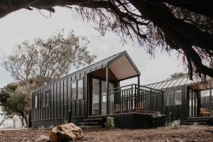 a black house with large glass windows on a field at Tasman Holiday Parks - Yallingup Beach in Yallingup
