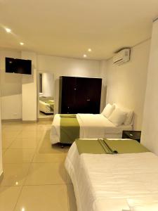 a hotel room with two beds and a television at Santelmo Hotel Cali in Cali