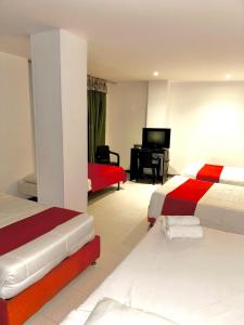 a hotel room with two beds and a television at Santelmo Hotel Cali in Cali