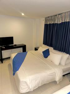 a bedroom with a large white bed with blue pillows at Santelmo Hotel Cali in Cali +1 photo