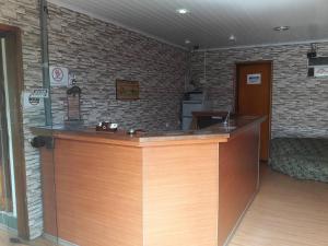 a bar in a room with a brick wall at Pousada Miniférico in Campos do Jordão