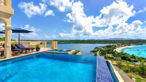 a swimming pool with a view of the water at Villa Nirvana in North Hill Village