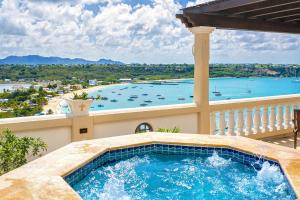a hot tub on a balcony with a view of the ocean at Villa Nirvana in North Hill Village