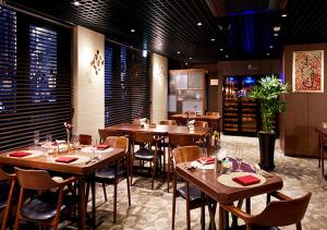 a restaurant with wooden tables and chairs in a room at Ramada by Wyndham Gumi in Gumi