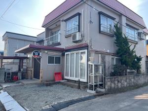 a house with a red bench in front of it at Lodging House NAO in Aomori