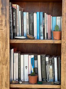 a book shelf filled with books and potted plants at Casa De Amigos Hotel Boutique in Honda