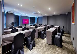 a conference room with tables and chairs and a screen at Ramada by Wyndham Gumi in Gumi