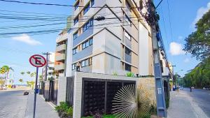 a building with a garage on the side of a street at Mahalo Flat Cabo Branco Genius Flats in João Pessoa