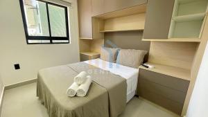 a small bedroom with a bed with towels on it at Mahalo Flat Cabo Branco Genius Flats in João Pessoa
