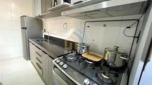 a small kitchen with a stove and a sink at Mahalo Flat Cabo Branco Genius Flats in João Pessoa