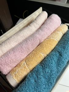 four different colored towels sitting on a shelf at Lodging House NAO in Aomori +75 photos