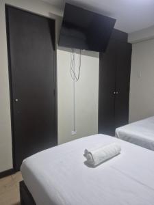 a hotel room with two beds and a towel on the bed at Hotel Naciones Unidas in Lima