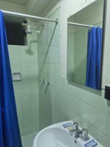 a bathroom with a sink and a mirror and a shower at Hotel Naciones Unidas in Lima