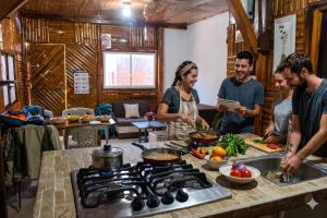 a group of people standing in a kitchen preparing food at Soga Hostal in Santa Marianita