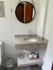 a bathroom with a sink and a mirror at Apartamento confortável, calmo e bem localizado in Lucas do Rio Verde