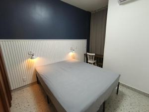 a bedroom with a white bed with lights on it at Flat Assinado e Sofisticado in Vitória