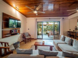 a living room with a couch and a ceiling fan at Beach Heaven in Playa Guiones