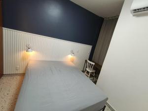 a bedroom with a white bed and a chair at Flat Assinado e Sofisticado in Vitória